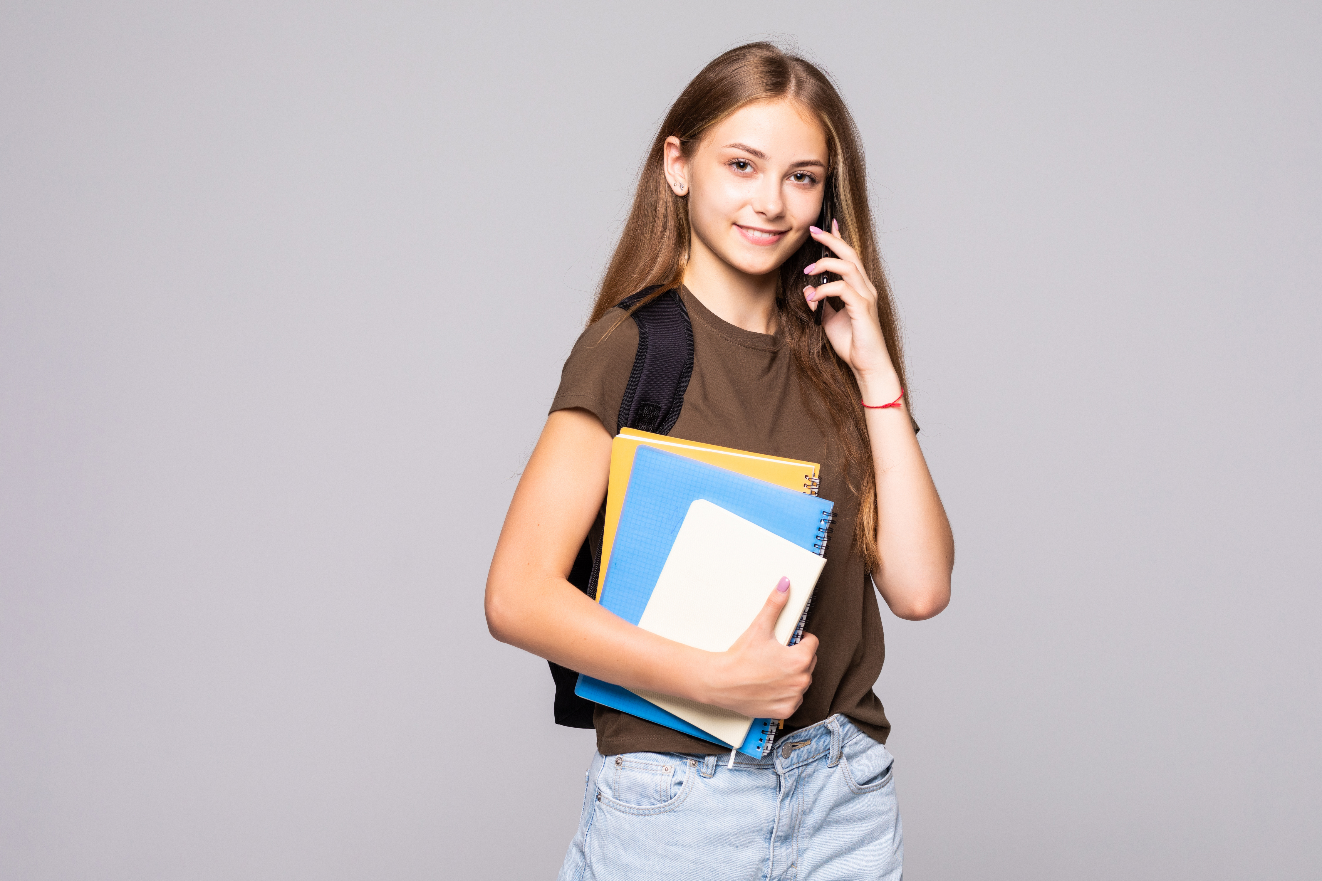 Happy smiling woman student talking on the phone isolated on white background